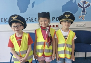 11.Antek i Ignacy w czapkach pilotów oraz Klara w toczku i apaszce stewardesy pozują do zdjęcia.