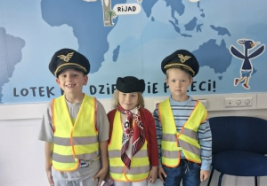 12.Franek, Nadia i Julek pozują do zdjęcia w czapkach pilota i toczku stewardesy.