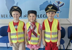 16.Wojtuś K., Maja i Oskar pozują do zdjęcia w czapkach pilota i toczku stewardesy.