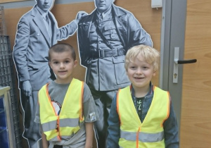 4.Staś i Karol stoją przed wizerunkami Żwirko i Wigury w sali historycznej.