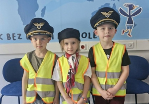 8.Wojtuś Z. i Lucjan w czapkach pilotów oraz Zuzia w toczku stewardesy pozują do zdjęcia.