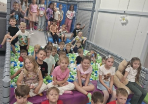 16.Dzieci siedzą w basenie z piłeczkami.