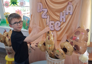 10.Mikołaj wybiera sobie balon w kształcie kapibary. W tle dekoracja z okazji Dnia Dziecka.