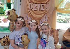 13.Trzy dziewczynki pozują do zdjęcia na tle dekoracji.