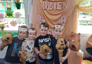 14.Czwórka chłopców pozuje do zdjęcia na tle dekoracji z otrzymanymi upominkami.