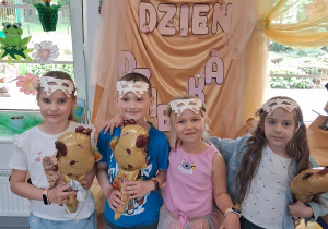 16.Grupka dzieci pozuje do zdjęcia na tle dekoracji.