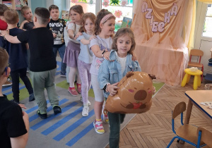 20.Amanda trzyma balon w kształcie kapibary i prowadzi „pociąg”.