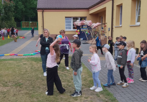 Biedronki ustawione jeden za drugim, celują piłkę do kosza.