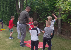 Dzieci ze Słoneczek wspólnie z panem Łukaszem przeciągają linę.