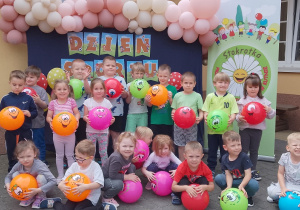 Motylki pozują do zdjęcia grupowego z piłkami zasponsorowanymi przez Urząd Miasta.