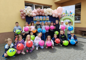 Biedronki pozują do zdjęcia grupowego z piłkami zasponsorowanymi przez Urząd Miasta.