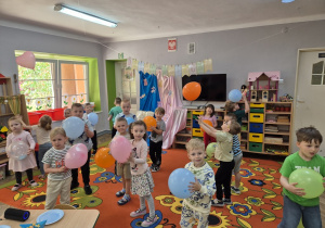 11. Przedszkolaki poruszają się na dywanie z balonami w trakcie zabawy z piosenką.