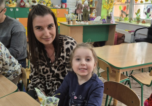 3. Na zdjęciu uśmiechnięta Wiktoria z mamą. Dziewczynka trzyma wykonanego zajączka z papierowego kubeczka.
