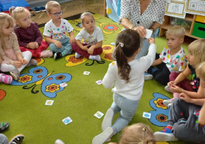 6. Dzieci siedzą na dywanie, odgadują zagadki słowne i wykonują polecenia nauczyciela.
