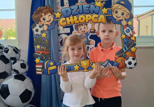 21. Chłopiec z dziewczynką pozują w ramce z napisem Dzień Chłopca.