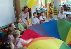 4. Pani wraz z dziećmi biorą udział w radosnej zabawie z chustą animacyjną.