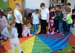 6. Dzieci stoją na chuście animacyjnej.