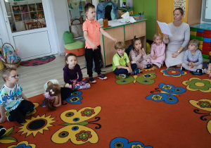 7. Chłopiec stoi w kole i odpowiada na zagadkę.