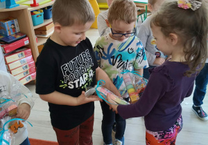 9. Dziewczynka wręcza chłopcu prezent.