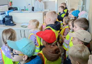 6. Dzieci stoją w dyspozytorni Miejskiego Zakładu Komunikacji i słuchają jak pan opowiada czym się zajmuje.