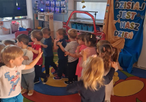 17. Chłopiec prowadzi dzieci ustawione w "węża". W tle dekoracja z okazji Dnia Chłopca.