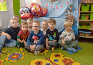 11. Chłopcy pozują do zdjęcia, w tle napis Dzień chłopaka.