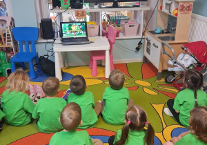 2.Dzieci siedzą na dywanie i oglądają film edukacyjny "Dzień drzewa”.