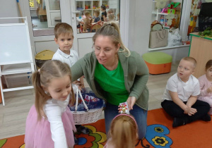 3.Dwoje przedszkolaków z grupy Motylki przyniosły poczęstunek pani z grupy Biedronki.