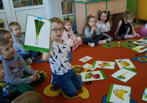 2. Chłopiec trzyma w ręku ilustrację pora.