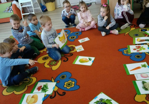 4. Chłopiec trzyma w ręku obrazek z bananami.