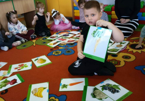 5. Chłopiec trzyma w ręku obrazek pietruszki.