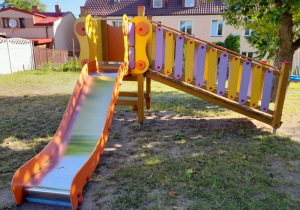 Zjeżdżalnia na placu zabaw w "Stokrotce". W tle budynki mieszkalne.