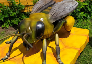 Rzeźba pszczoły na plastrze miodu.